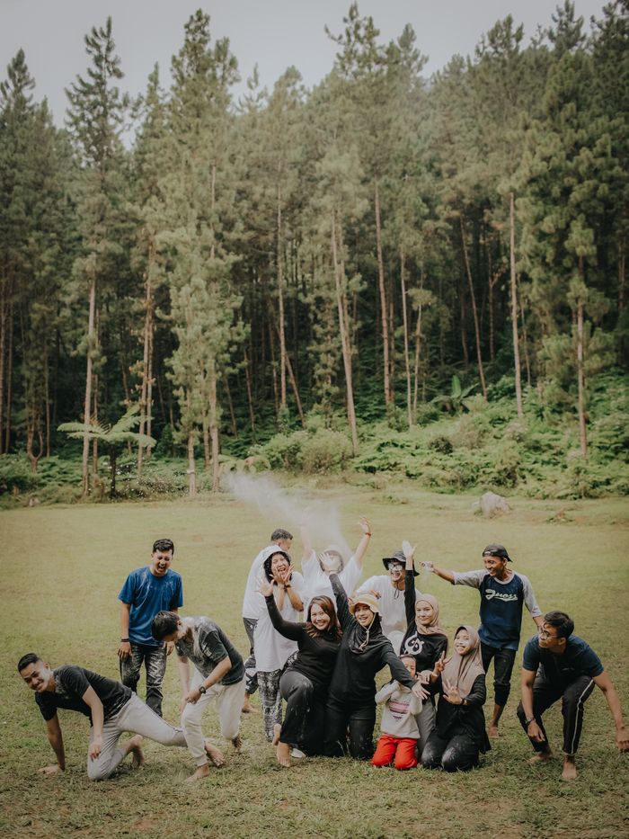 A cheerful group of friends posing in a pine forest in Java, capturing a joyful moment together.